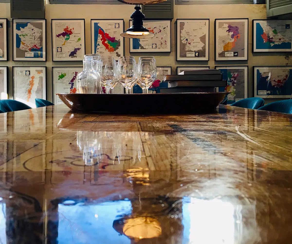 De proeftafel met wijnkaarten aan de muur (foto: Vughtse Wijnkoperij)